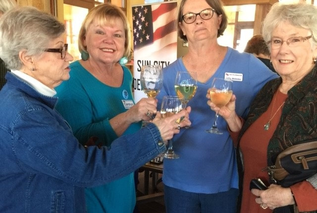 4 women toasting with wine glasses