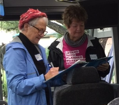 photo of the bus trip organizers checking their lists